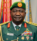 Nigerian Defence Chief speaking at a podium, addressing visa denial"
